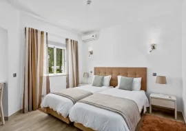 Bedroom with two beds. white covers with brown and cream curtains